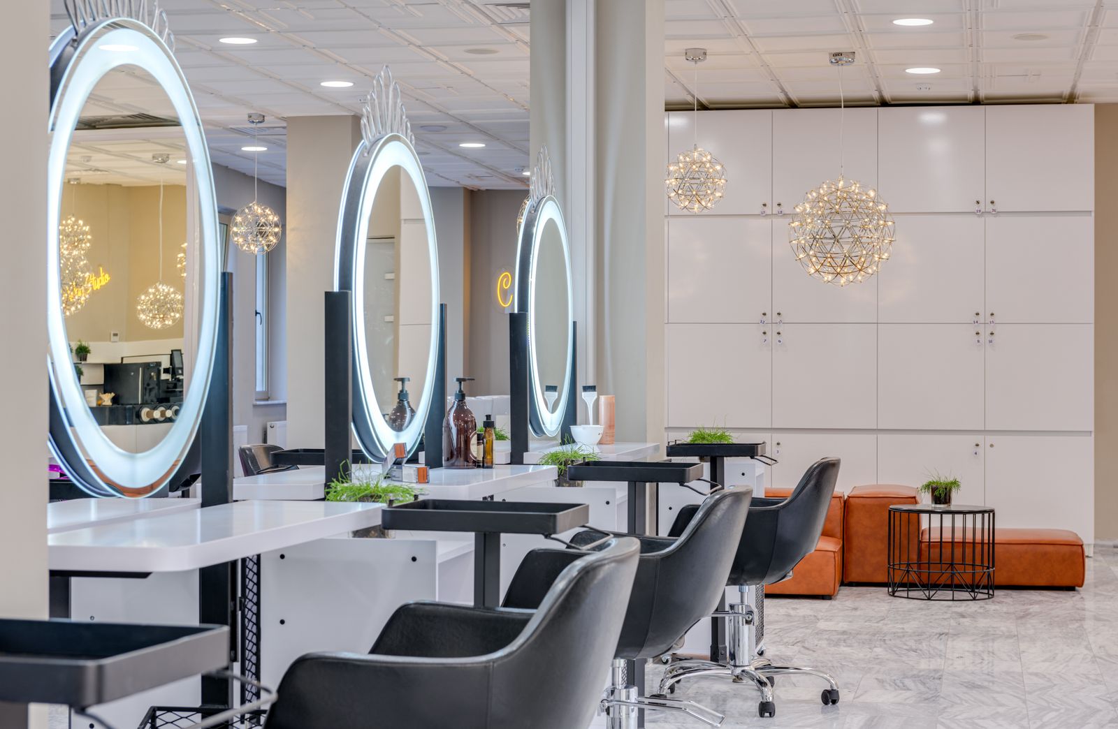The unisex hair studio, with styling chairs facing lit round mirrors